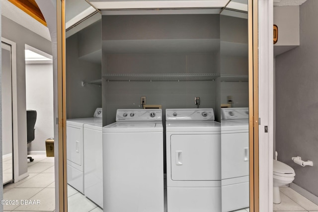 laundry area featuring light tile patterned floors, baseboards, laundry area, and separate washer and dryer