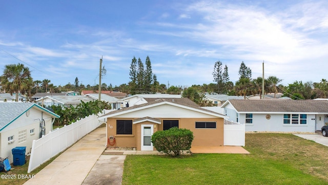 ranch-style house featuring fence, a front lawn, and stucco siding