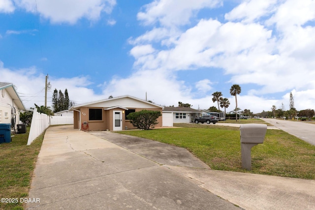 view of front of home with driveway, central air condition unit, fence, and a front lawn