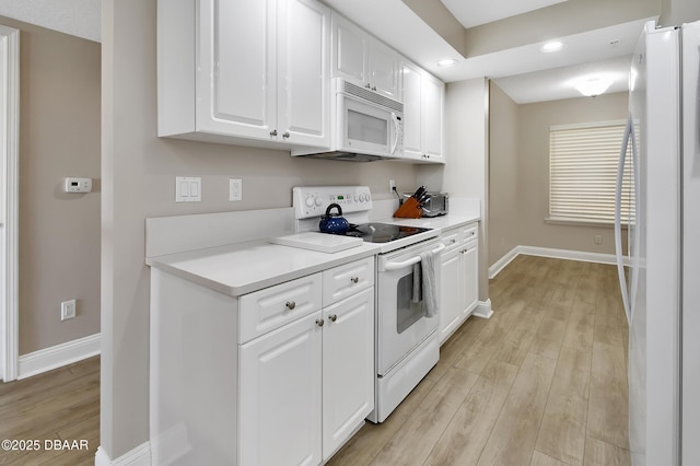 4670 Links Village Dr Unit A506, Ponce Inlet, FL 32127 - kitchen featuring white appliances, baseboards, light wood-style floors, light countertops, and white cabinets