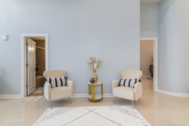 sitting room with baseboards and tile patterned flooring
