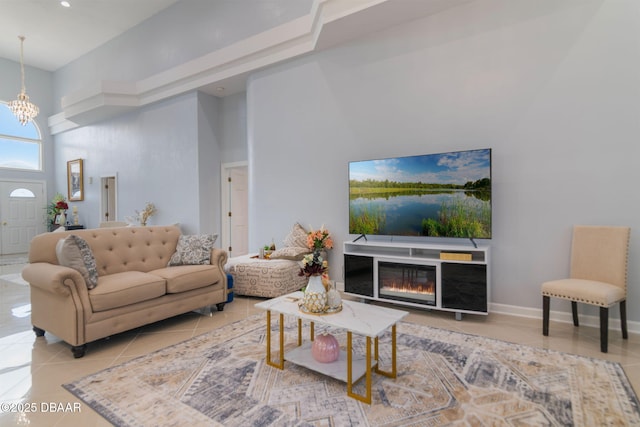 tiled living room with a glass covered fireplace, a high ceiling, recessed lighting, and a notable chandelier