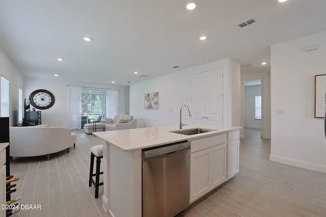 kitchen featuring light wood-type flooring, sink, an island with sink, white cabinets, and dishwasher