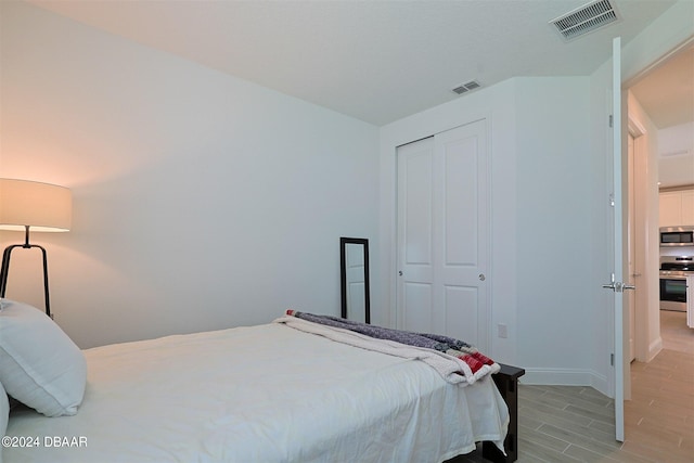 bedroom with light hardwood / wood-style flooring and a closet