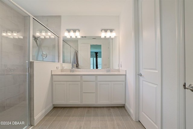 bathroom with vanity, hardwood / wood-style flooring, and a shower with shower door