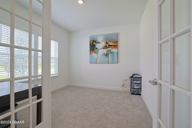 spare room with french doors and light colored carpet