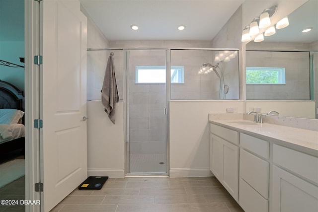 bathroom with vanity, a healthy amount of sunlight, and an enclosed shower