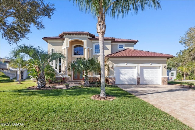 mediterranean / spanish-style home with a garage, stucco siding, decorative driveway, and a front lawn