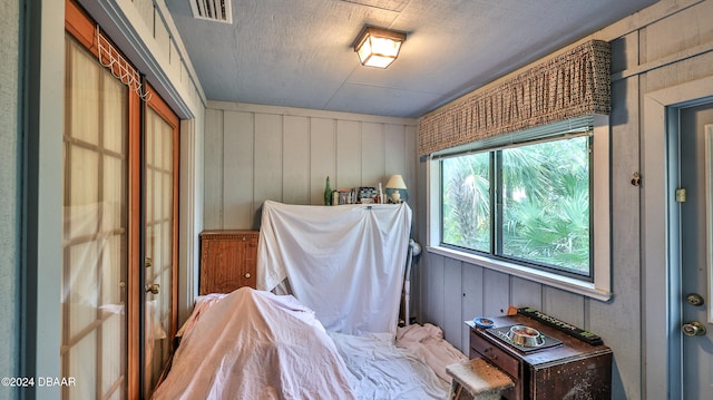 bedroom featuring wood walls