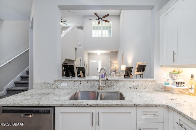 3417 Medici Blvd, New Smyrna Beach, FL 32168 - kitchen featuring stainless steel dishwasher, a ceiling fan, white cabinetry, light stone counters, and a high ceiling