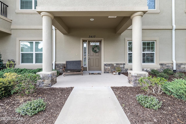 3417 Medici Blvd, New Smyrna Beach, FL 32168 - doorway to property featuring stucco siding, stone siding, and a porch