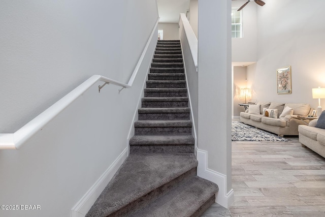 3417 Medici Blvd, New Smyrna Beach, FL 32168 - staircase with wood finished floors, ceiling fan, and a towering ceiling