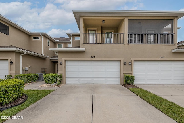 3417 Medici Blvd, New Smyrna Beach, FL 32168 - view of property featuring stucco siding, a garage, and driveway