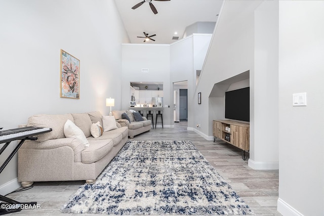 3417 Medici Blvd, New Smyrna Beach, FL 32168 - living area with a ceiling fan, a towering ceiling, and light wood-style flooring