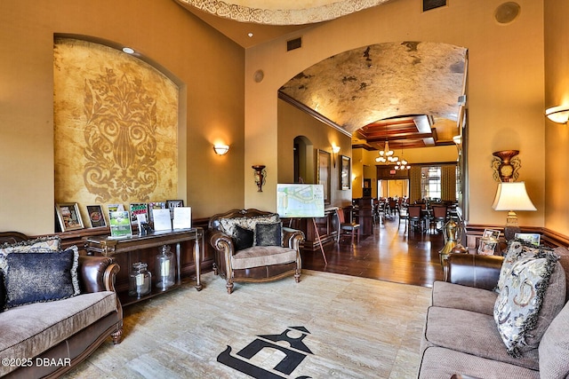 3417 Medici Blvd, New Smyrna Beach, FL 32168 - living room with arched walkways, a chandelier, high vaulted ceiling, wood finished floors, and crown molding