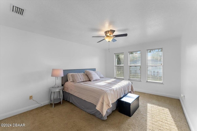 carpeted bedroom with a textured ceiling and ceiling fan