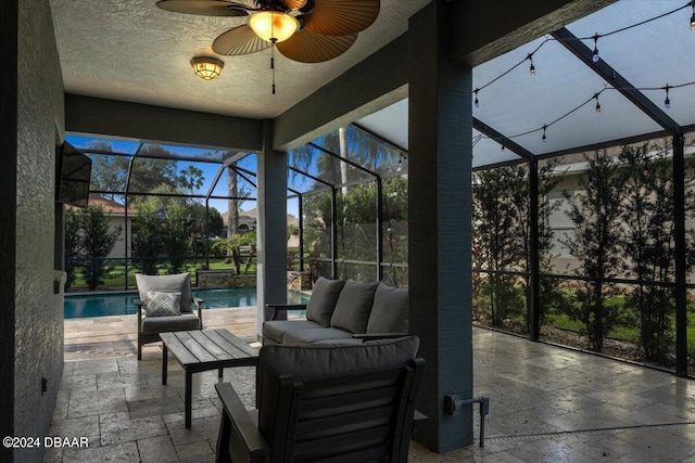 view of patio / terrace featuring glass enclosure, an outdoor hangout area, and ceiling fan