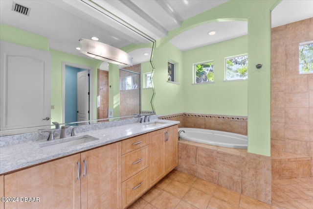 bathroom with tile patterned flooring, a wealth of natural light, vanity, and shower with separate bathtub