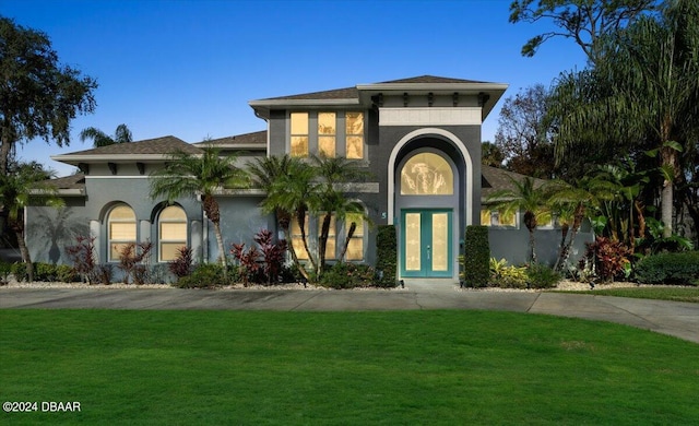 view of front of house with a front lawn and french doors