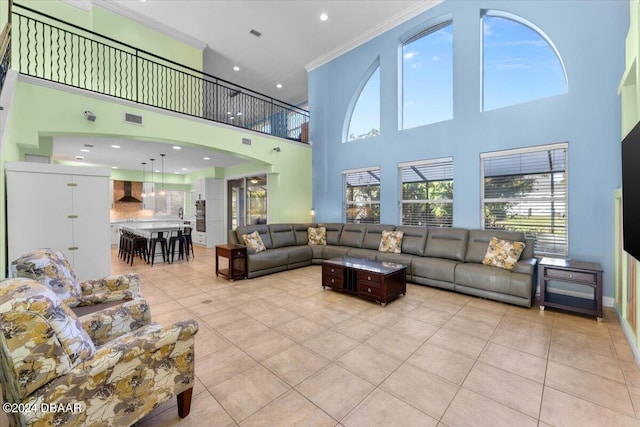 living room with light tile patterned flooring, crown molding, and a towering ceiling