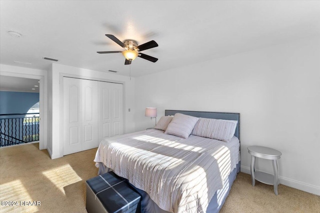 carpeted bedroom with ceiling fan and a closet