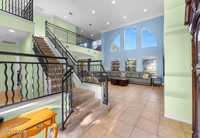 stairs featuring a high ceiling, tile patterned floors, and crown molding