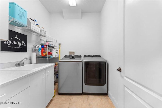 laundry area featuring cabinets, sink, washer and dryer, and light tile patterned floors