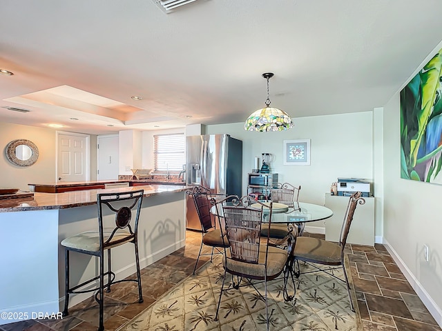 dining space featuring a raised ceiling