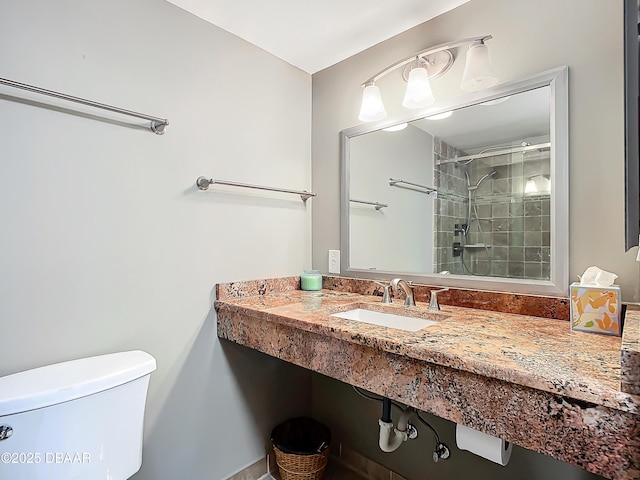 bathroom with tiled shower, toilet, and sink