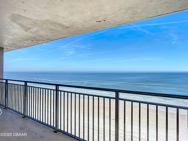 balcony featuring a water view and a view of the beach