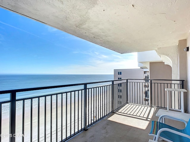 balcony featuring a water view and a view of the beach