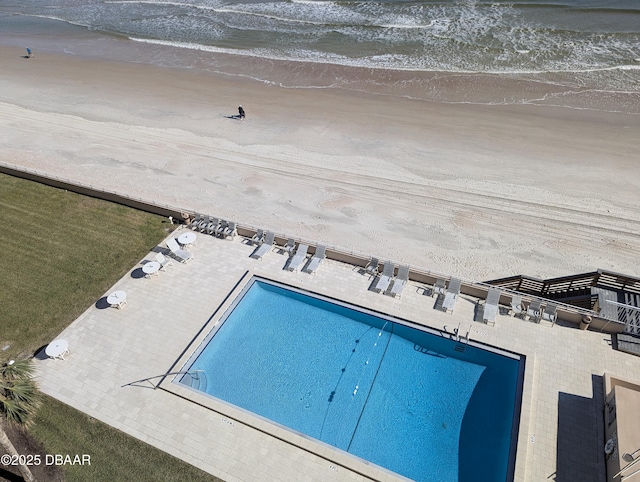 view of pool with a view of the beach and a water view