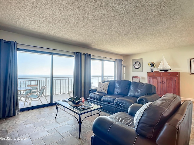 living room with a water view and a textured ceiling