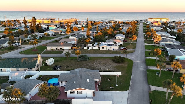 aerial view at dusk featuring a water view