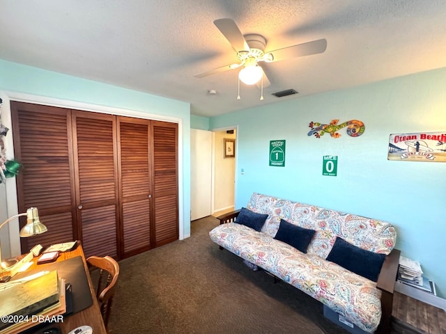 carpeted living area featuring a textured ceiling, visible vents, and a ceiling fan