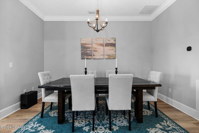 dining space featuring ornamental molding, hardwood / wood-style flooring, and a chandelier