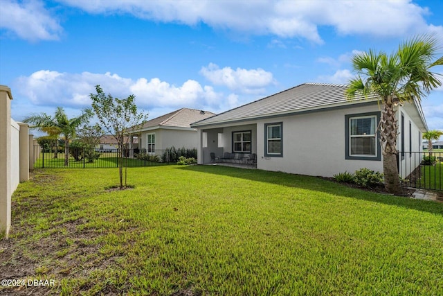 back of house with a yard and a patio area