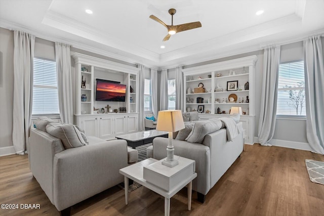 living room featuring hardwood / wood-style floors, a healthy amount of sunlight, and a tray ceiling