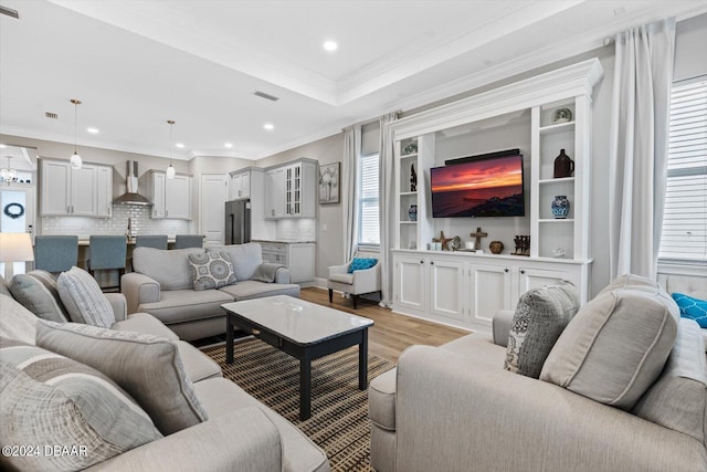 living room featuring light hardwood / wood-style flooring and crown molding