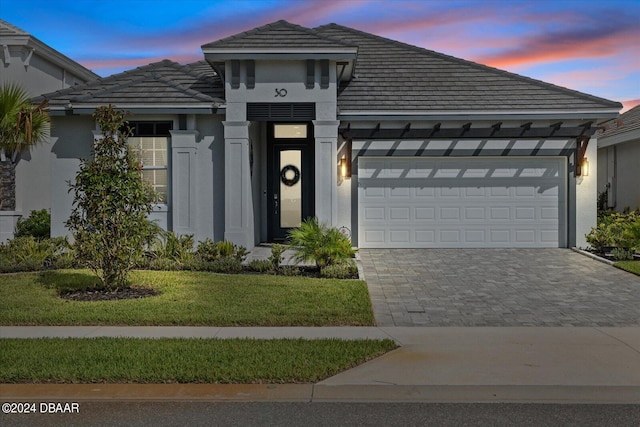 view of front facade featuring a garage and a lawn