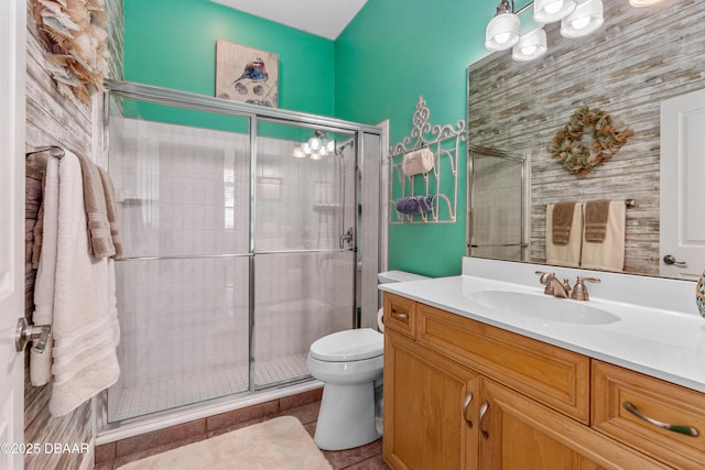 bathroom featuring a notable chandelier, a stall shower, toilet, and vanity