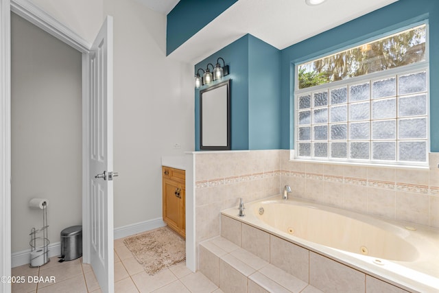 bathroom with tile patterned floors, a jetted tub, vanity, and baseboards