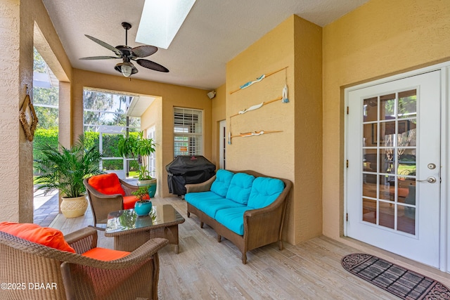 sunroom / solarium with a skylight and a ceiling fan