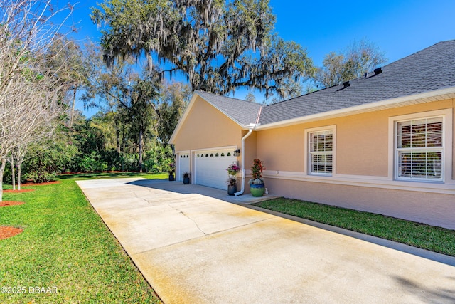 view of side of home with a shingled roof, stucco siding, driveway, a yard, and an attached garage