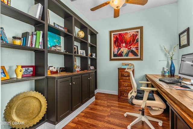 office space featuring dark wood-type flooring, baseboards, and ceiling fan