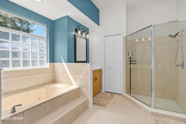 full bathroom featuring tile patterned flooring, a stall shower, vanity, and a garden tub