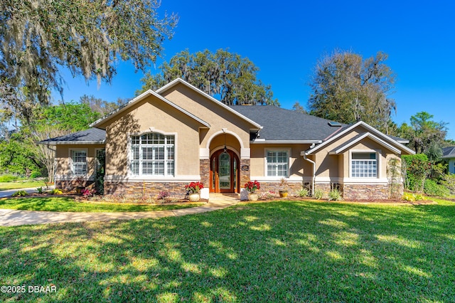 ranch-style house with a front yard, stone siding, and stucco siding