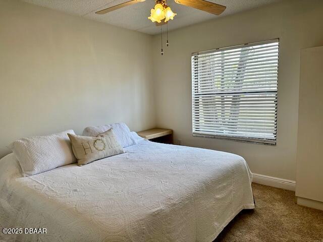 bedroom featuring a textured ceiling, carpet floors, and ceiling fan