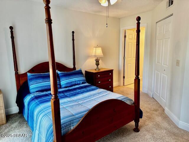 bedroom with light colored carpet and a closet