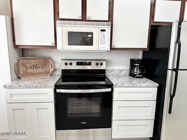 kitchen featuring white cabinetry and white appliances